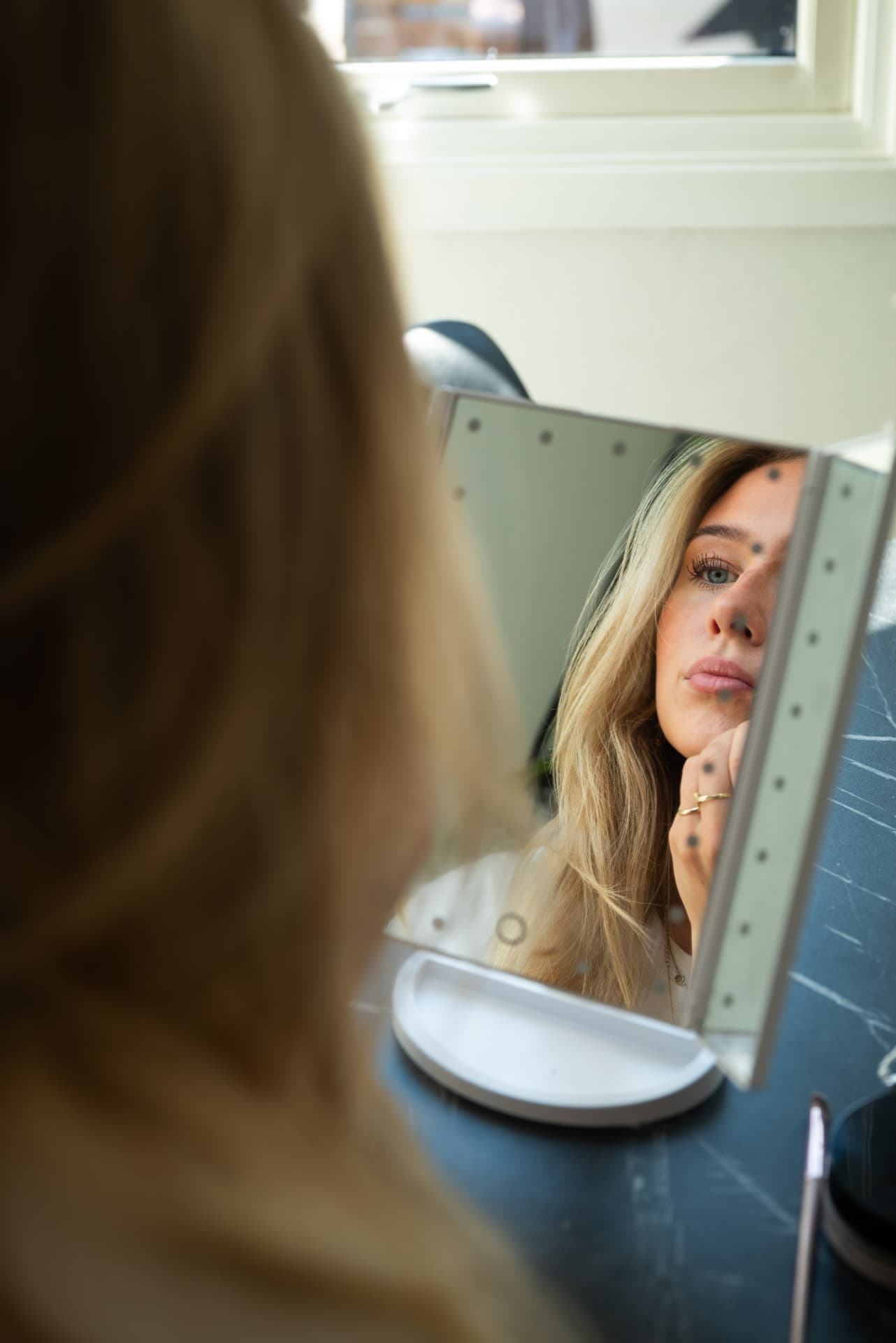 Vilde legger leppestift i speil med naturlig lys